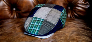 The Dad 2.0 is here showing the blue and green patchwork Dad cap sitting on a leather chair