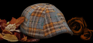 The Autumn Rose Scally Cap is here, featuring and orange and grey plaid. Product shown against black background with fall leaves and roses.